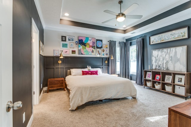 carpeted bedroom with crown molding, a raised ceiling, ceiling fan, and recessed lighting