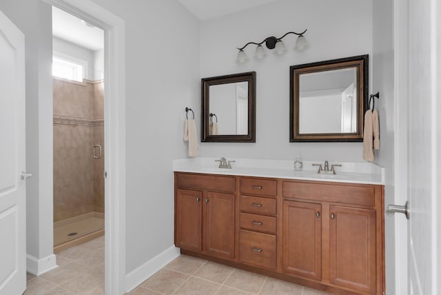 bathroom featuring baseboards, tile patterned floors, a sink, and a stall shower