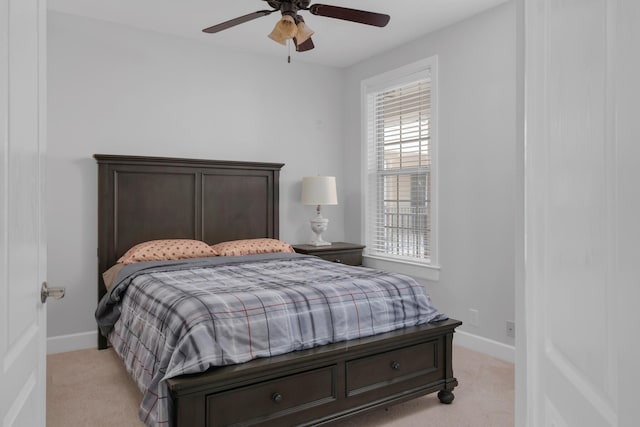 bedroom featuring a ceiling fan, baseboards, and light carpet