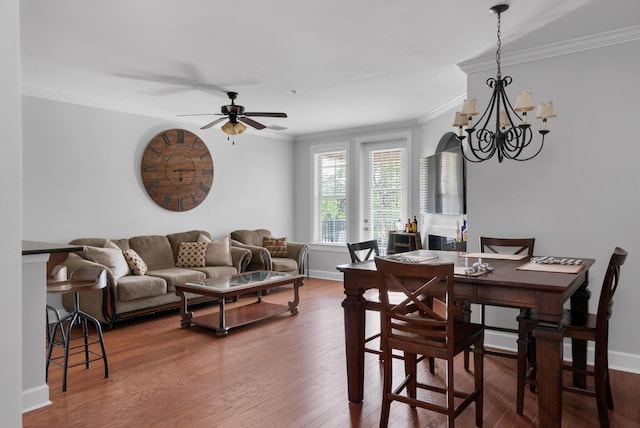 dining room with crown molding, baseboards, ceiling fan with notable chandelier, and hardwood / wood-style floors