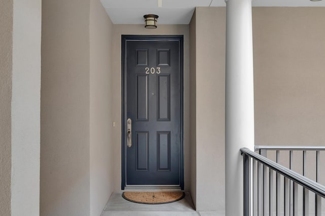 doorway to property featuring stucco siding