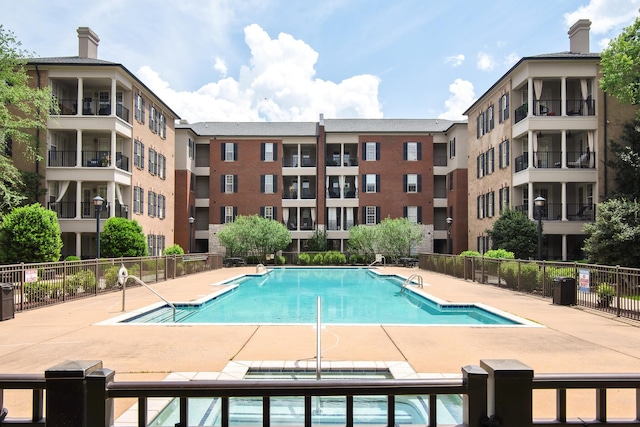 pool featuring fence and a patio area