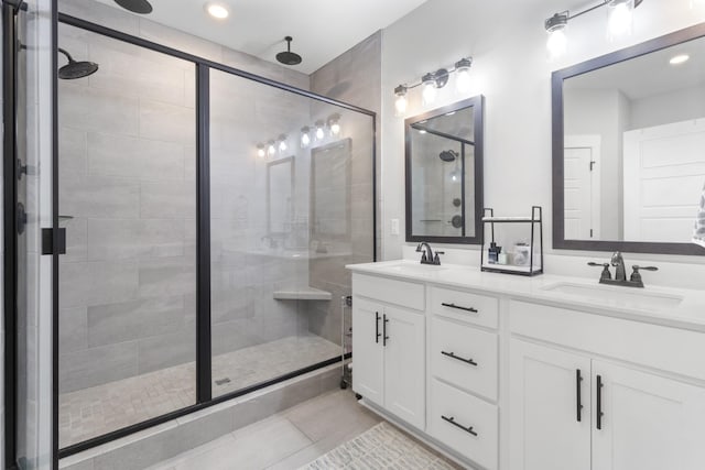 bathroom with double vanity, tile patterned floors, a shower stall, and a sink