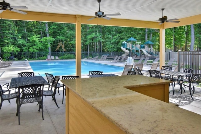 pool featuring outdoor dining area, a ceiling fan, fence, and a patio