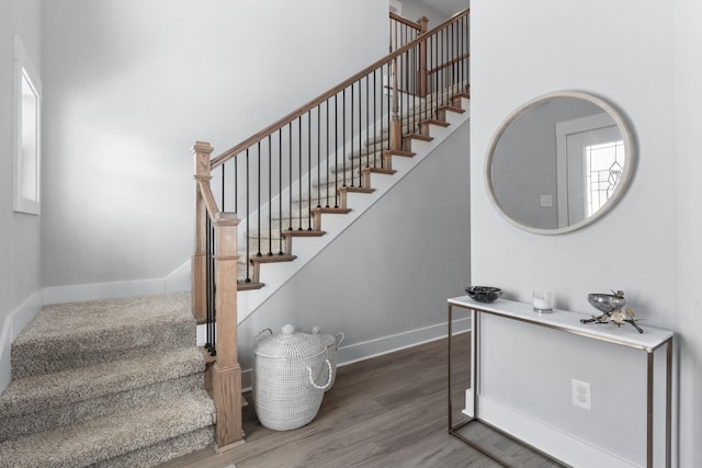 staircase featuring baseboards and wood finished floors