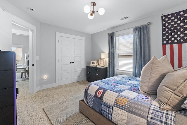 carpeted bedroom featuring baseboards, a closet, and visible vents