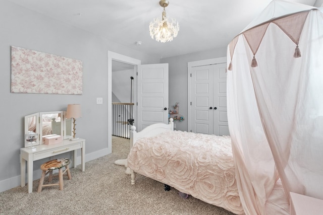 carpeted bedroom with baseboards, a chandelier, and a closet