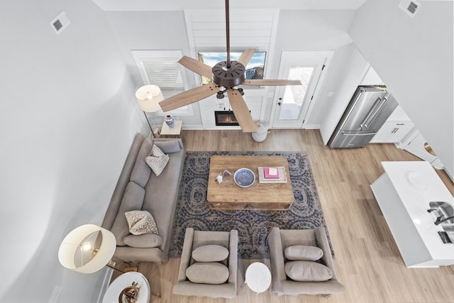 interior space with visible vents, a ceiling fan, and wood finished floors