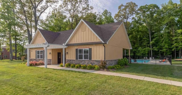 craftsman-style home featuring a shingled roof, board and batten siding, a pergola, and stone siding