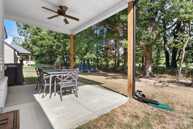 view of patio / terrace featuring outdoor dining area, a fenced backyard, a trampoline, and ceiling fan