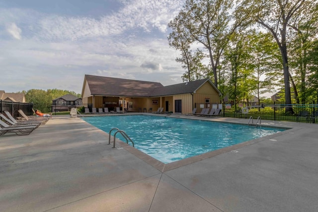 community pool with a patio and fence