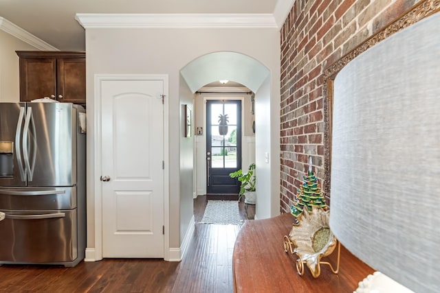 6006 Trotwood Ln, Spring Hill, TN 37174 - foyer entrance featuring arched walkways, brick wall, ornamental molding, and dark wood-type flooring