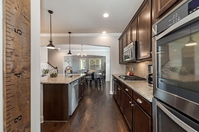 6006 Trotwood Ln, Spring Hill, TN 37174 - kitchen with crown molding, dark brown cabinetry, light stone counters, a sink, and stainless steel appliances