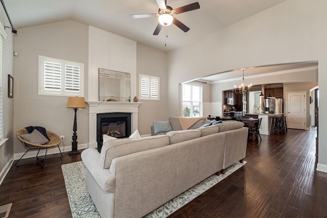 6006 Trotwood Ln, Spring Hill, TN 37174 - living area with a large fireplace, arched walkways, ceiling fan with notable chandelier, dark wood-style floors, and lofted ceiling
