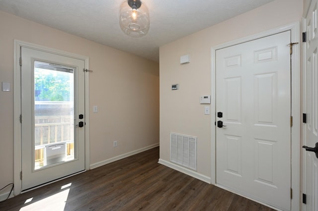 doorway to outside featuring baseboards, visible vents, and dark wood-style floors