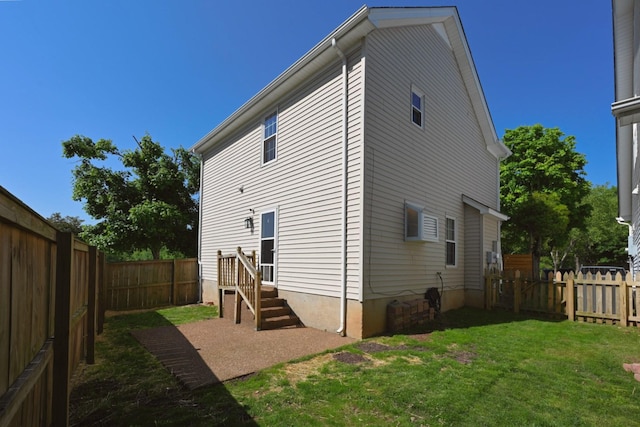 rear view of house featuring a fenced backyard and a yard