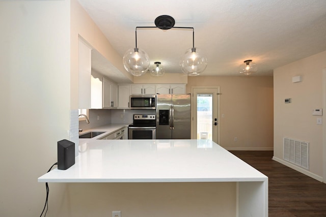 kitchen featuring a sink, light countertops, stainless steel appliances, a peninsula, and visible vents