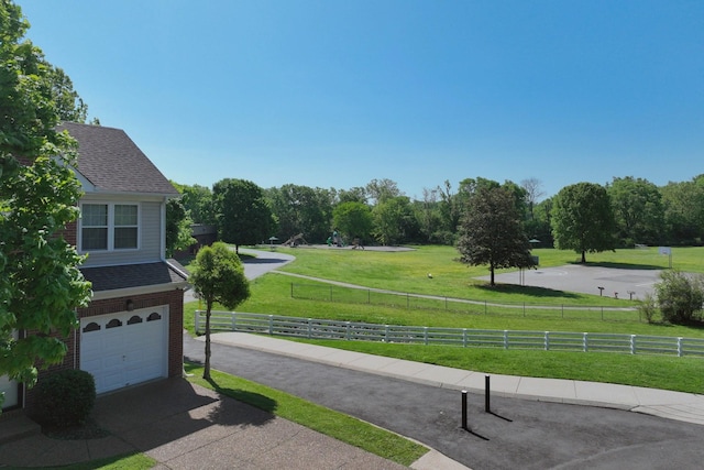 exterior space featuring an attached garage, fence, and driveway