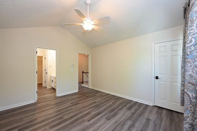 unfurnished bedroom featuring a ceiling fan, baseboards, lofted ceiling, and dark wood-type flooring