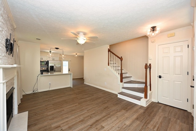 unfurnished living room featuring stairway, a textured ceiling, ceiling fan, and wood finished floors