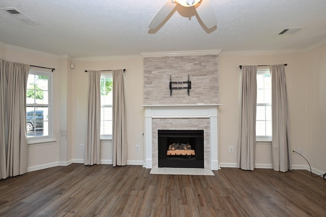 unfurnished living room with visible vents, a ceiling fan, wood finished floors, and a fireplace