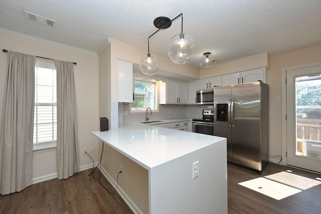 kitchen featuring appliances with stainless steel finishes, a peninsula, white cabinetry, visible vents, and dark wood-style floors