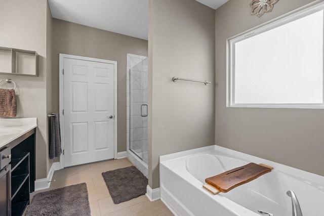 full bath featuring vanity, a shower stall, and a garden tub