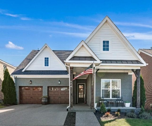 traditional-style house with brick siding, an attached garage, covered porch, and concrete driveway
