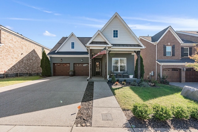 view of front of home featuring brick siding, a porch, a front yard, concrete driveway, and a standing seam roof