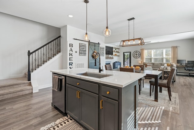 kitchen featuring a sink, wood finished floors, a barn door, and open floor plan