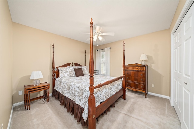 bedroom featuring a ceiling fan, baseboards, light colored carpet, and a closet