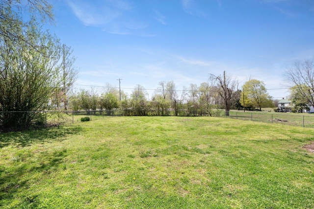 view of yard with fence and a rural view