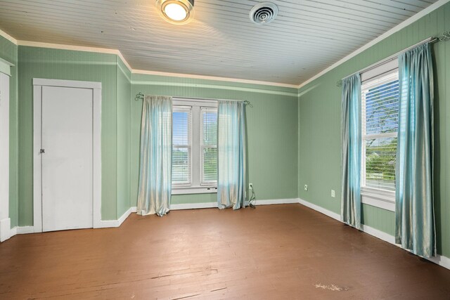 unfurnished room featuring baseboards, ornamental molding, hardwood / wood-style flooring, and visible vents