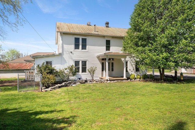 rear view of property with fence and a yard