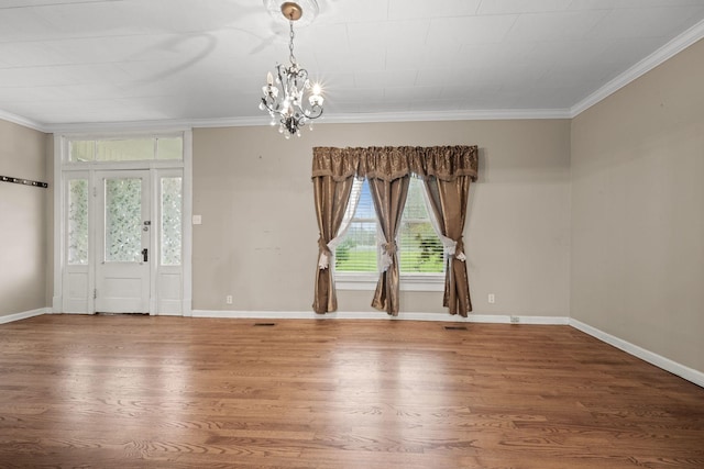 foyer with crown molding, visible vents, wood finished floors, and a chandelier