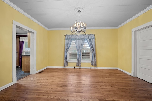 unfurnished dining area with baseboards, a notable chandelier, ornamental molding, and wood finished floors