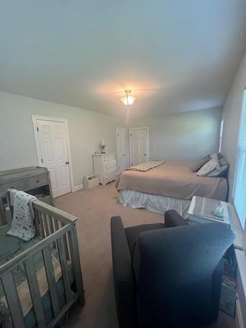 bedroom with baseboards, multiple windows, and carpet