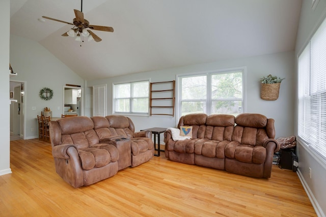 living room featuring high vaulted ceiling, baseboards, a ceiling fan, and wood finished floors