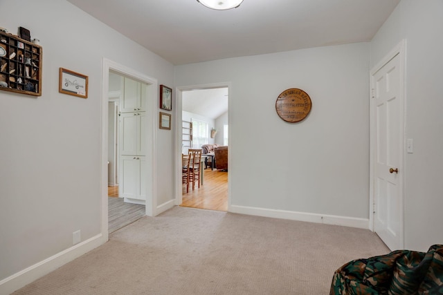 corridor featuring baseboards and carpet