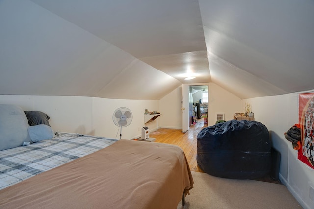bedroom with baseboards, visible vents, light wood-type flooring, and lofted ceiling