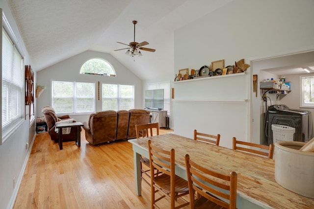 dining room with light wood-style floors, vaulted ceiling, and a ceiling fan