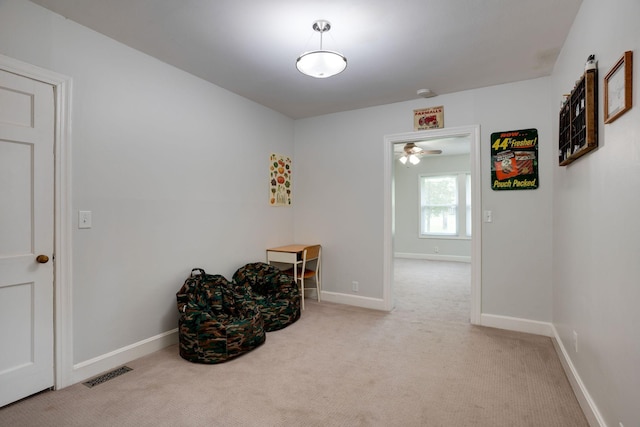 hall with visible vents, carpet, and baseboards