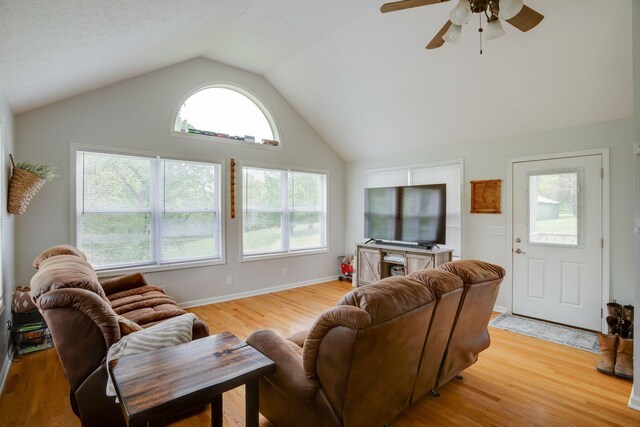 living area featuring a ceiling fan, light wood-type flooring, and lofted ceiling