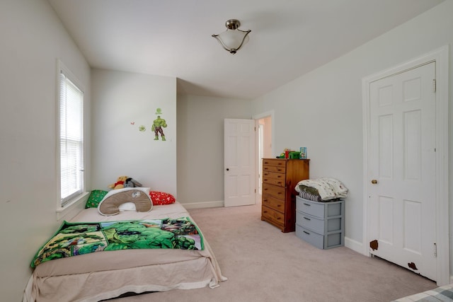 bedroom with baseboards and light carpet