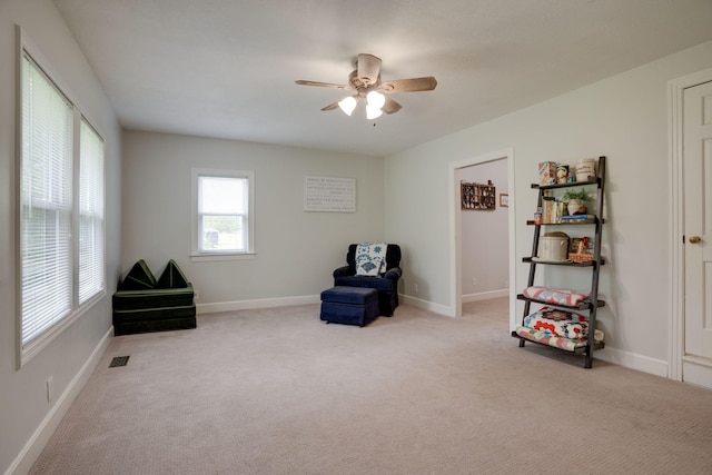 sitting room with ceiling fan, visible vents, baseboards, and carpet