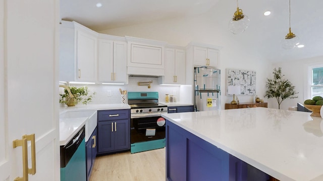 kitchen with freestanding refrigerator, blue cabinets, electric stove, dishwasher, and vaulted ceiling