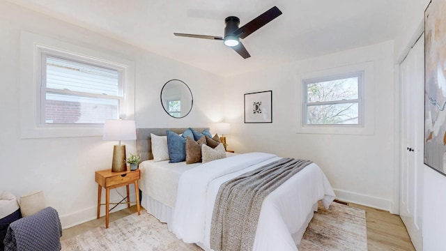 bedroom featuring a closet, baseboards, a ceiling fan, and light wood-type flooring
