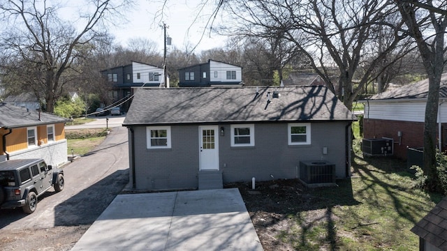 rear view of property with roof with shingles, a residential view, brick siding, cooling unit, and entry steps