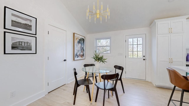 dining space featuring light wood-style floors, baseboards, lofted ceiling, and a notable chandelier