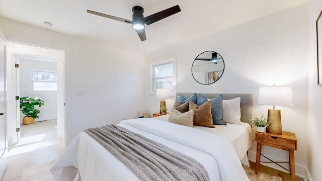 bedroom featuring baseboards, light wood finished floors, and ceiling fan